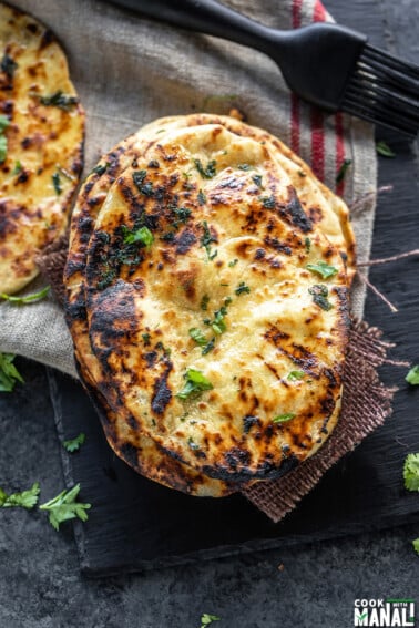 stack of naan garnished with cilantro and placed on a black board