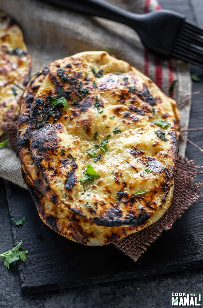 stack of naan garnished with cilantro and placed on a black board