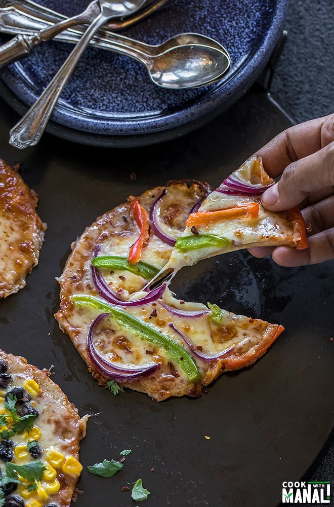 pair of hand pulling out a pizza slice