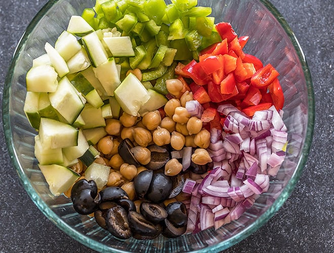 bowl with chickpeas, chopped onion,olives, cucumber and pepper