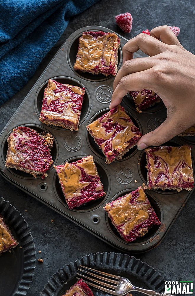 pair of hand holding a vegan peanut butter & jelly bar