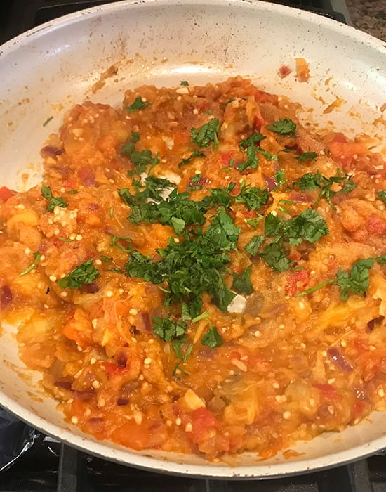 baingan bharta garnished with cilantro in a pan