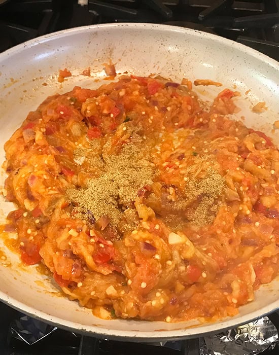 onion tomato masala with ground spices added in a pan