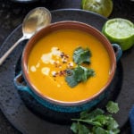 Thai Butternut Squash Soup served in a blue bowl with squeezed lime on the side