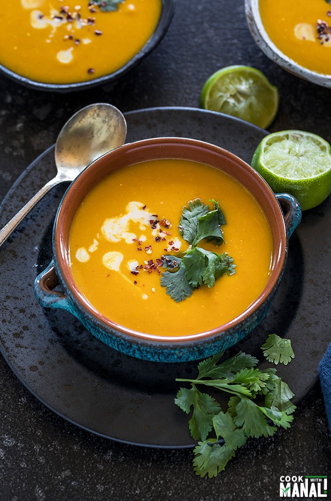 Thai Butternut Squash Soup served in a blue bowl with squeezed lime on the side