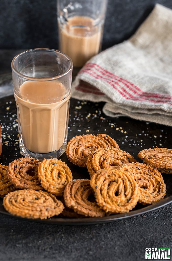 homemade instant chakli on a plate with a glass of chai in the background