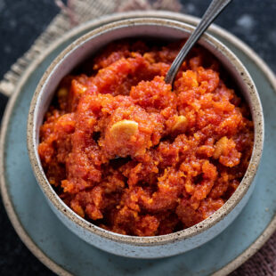 gajar halwa served in a bowl and topped with cashew