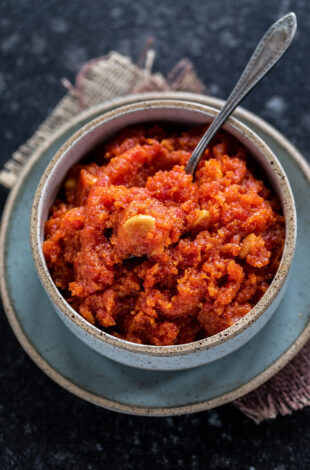 gajar halwa served in a bowl and topped with cashew