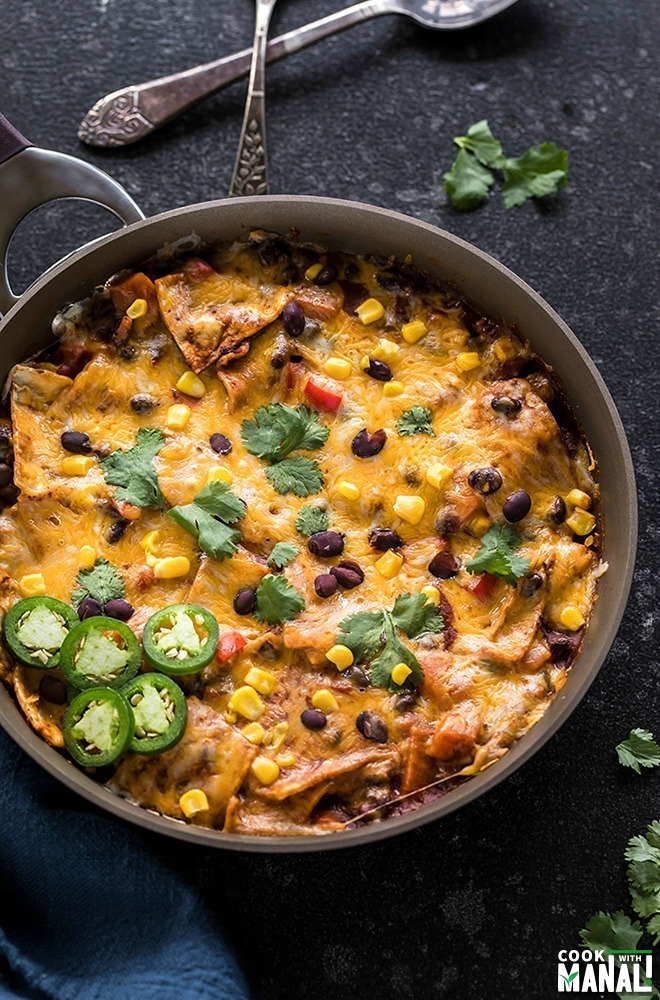 one-pot vegetarian enchiladas in a skillet garnished with cilantro and jalapenos
