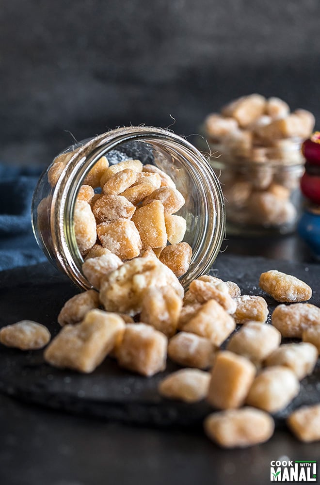 a tumbling glass container full of khurma with more khurma in the background