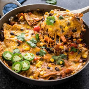 one-pot vegetarian enchiladas in a skillet with a spatula lifting of the cheese