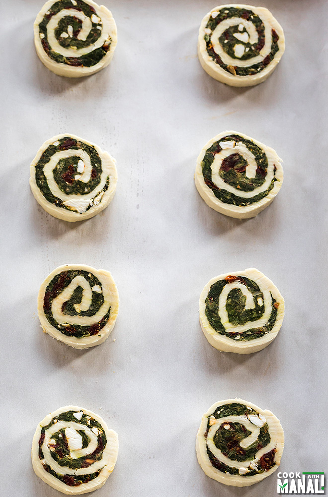 cut puff pastry pinwheels arranged on a baking tray