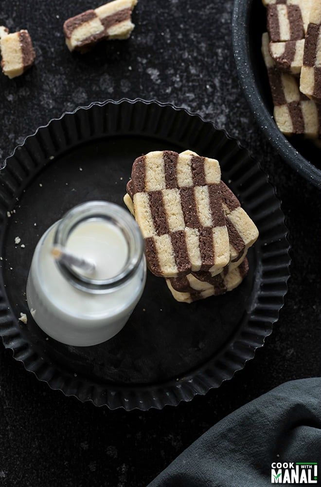 small stack of checkerboard cookies with a bottle of milk with straw