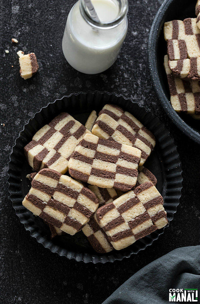 checkerboard cookies in a black rimmed plate