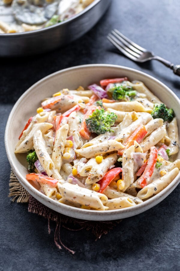bowl of white sauce pasta with veggies