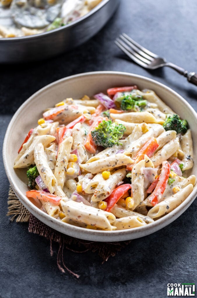 bowl of white sauce pasta with veggies