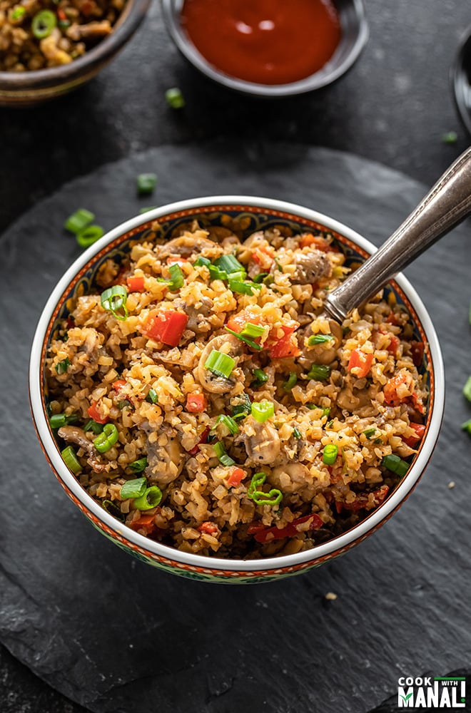 bowl of cauliflower fried rice with a spoon