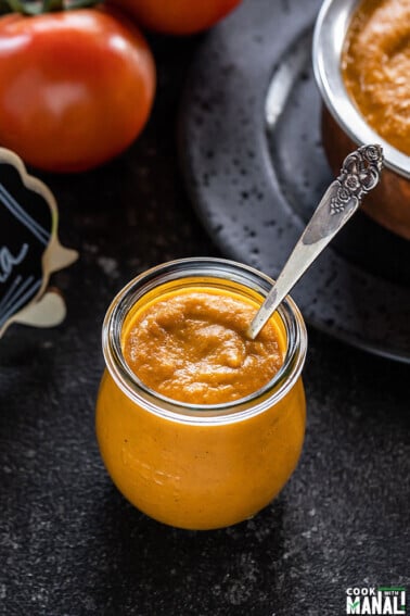 Indian Onion Tomato Masala in a glass jar with a spoon