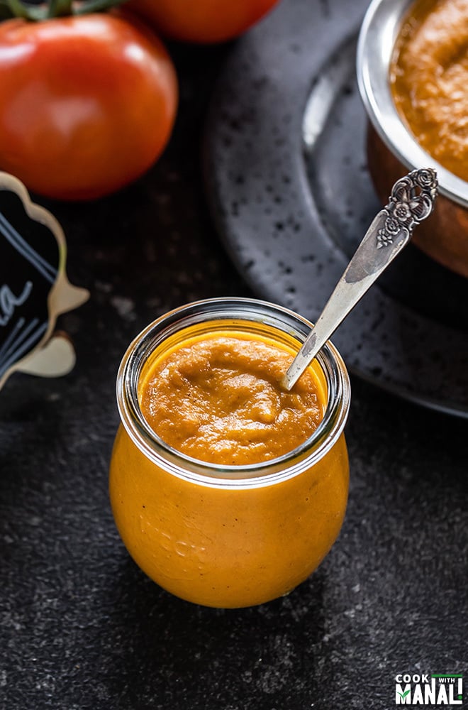 Indian Onion Tomato Masala in a glass jar with a spoon