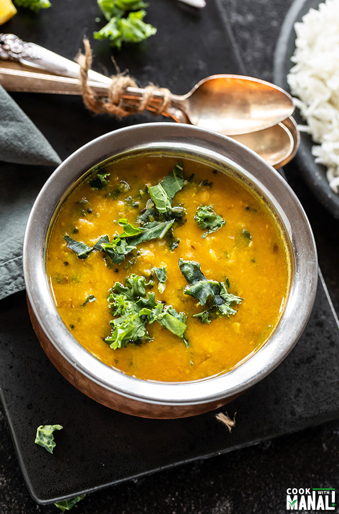 instant pot kale garlic dal in a copper round bowl with spoons and napkin in the background