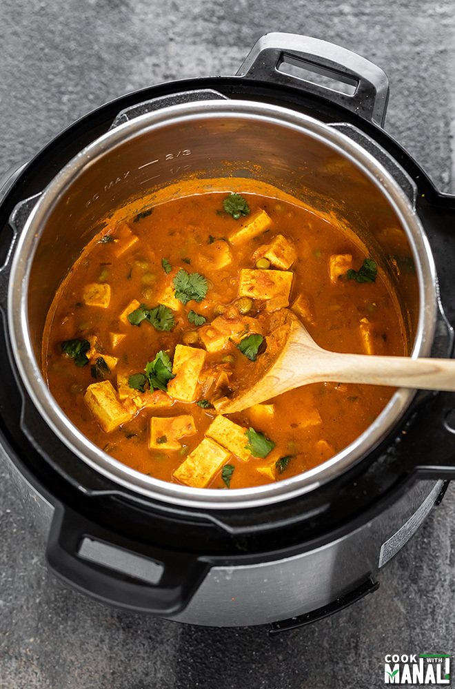 Instant Pot Tofu Matar with a wooden ladle