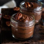 avocado chocolate pudding in a mason jar with more jars in the background