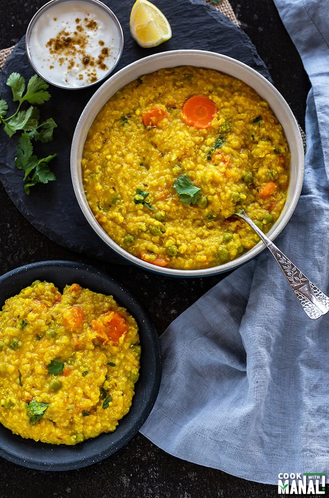 a large bowl of quinoa khichdi with a spoon alongside a small plate with more khichdi