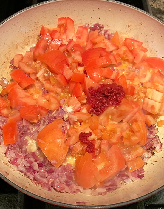 chopped tomatoes with onions in a pan