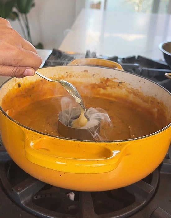 adding ghee to hot coal placed in a steel bowl