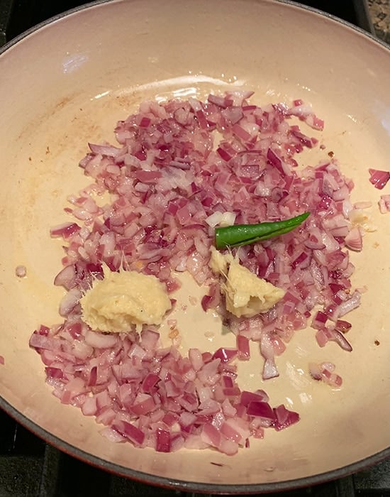 chopped onions with chilies and ginger garlic paste in a pan