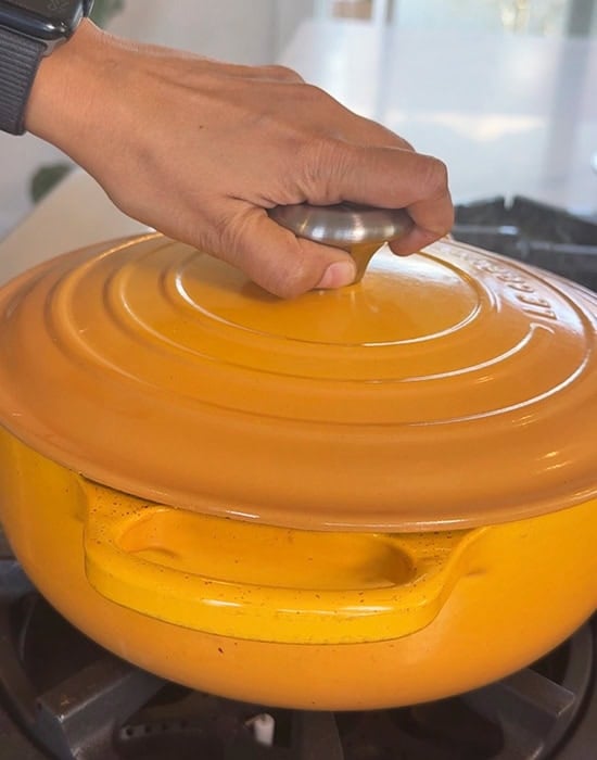 hand closing a yellow color pot with lid