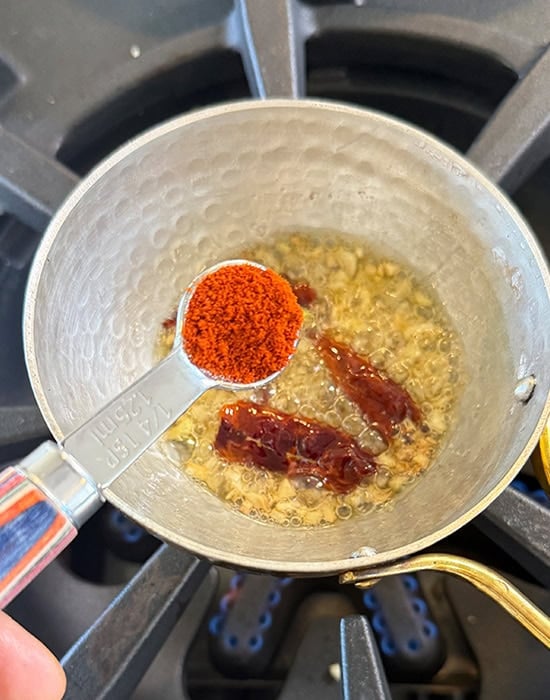 Kashmiri red chili powder being added to tadka for the dal