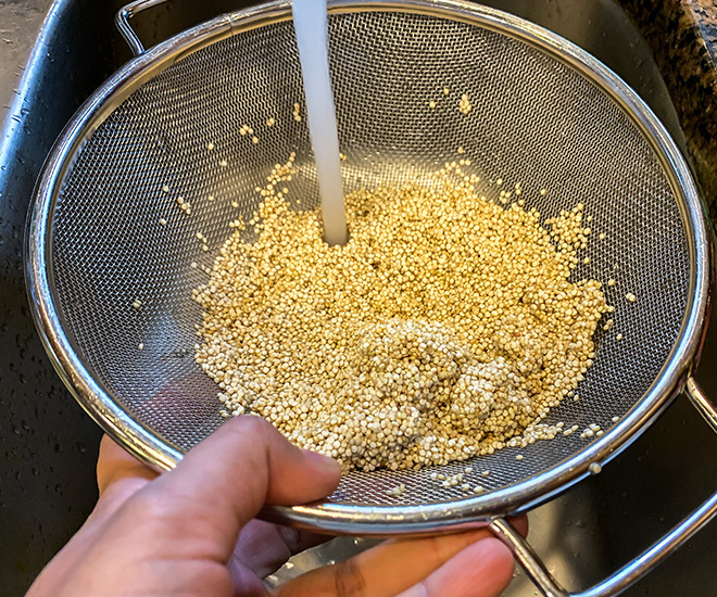 quinoa being rinsed in a colander