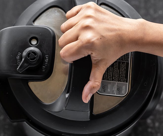 hand closing the instant pot with the lid