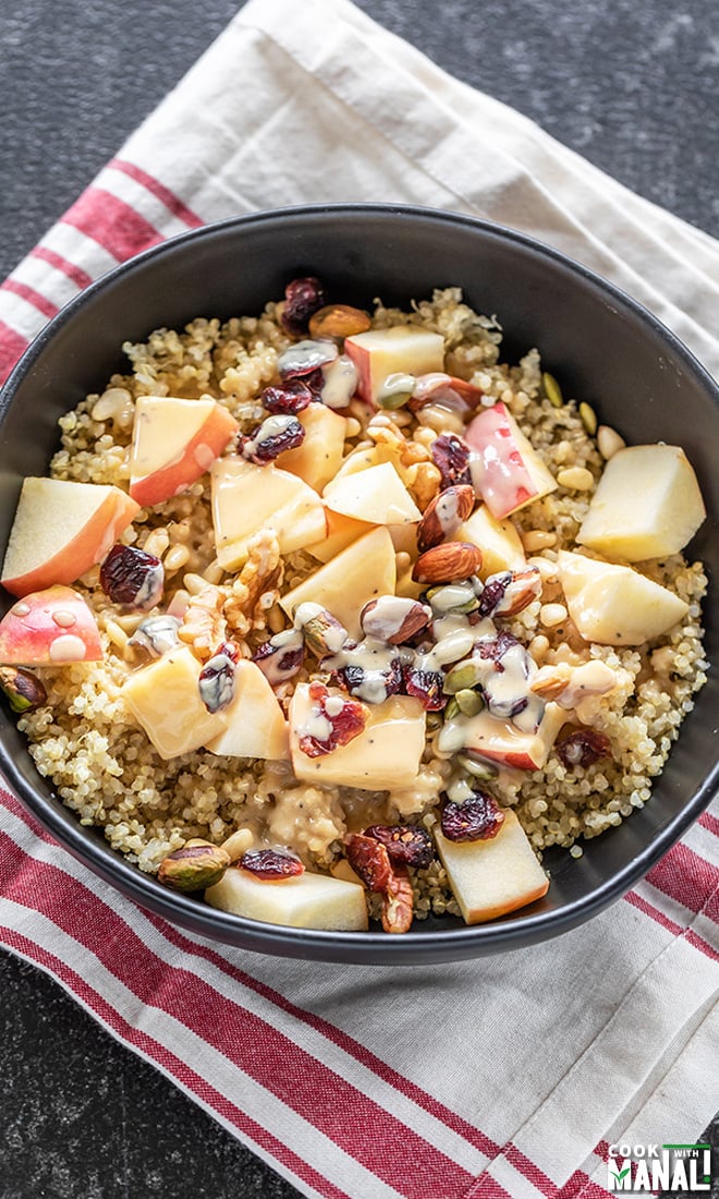 a bowl of quinoa salad with apples, nuts