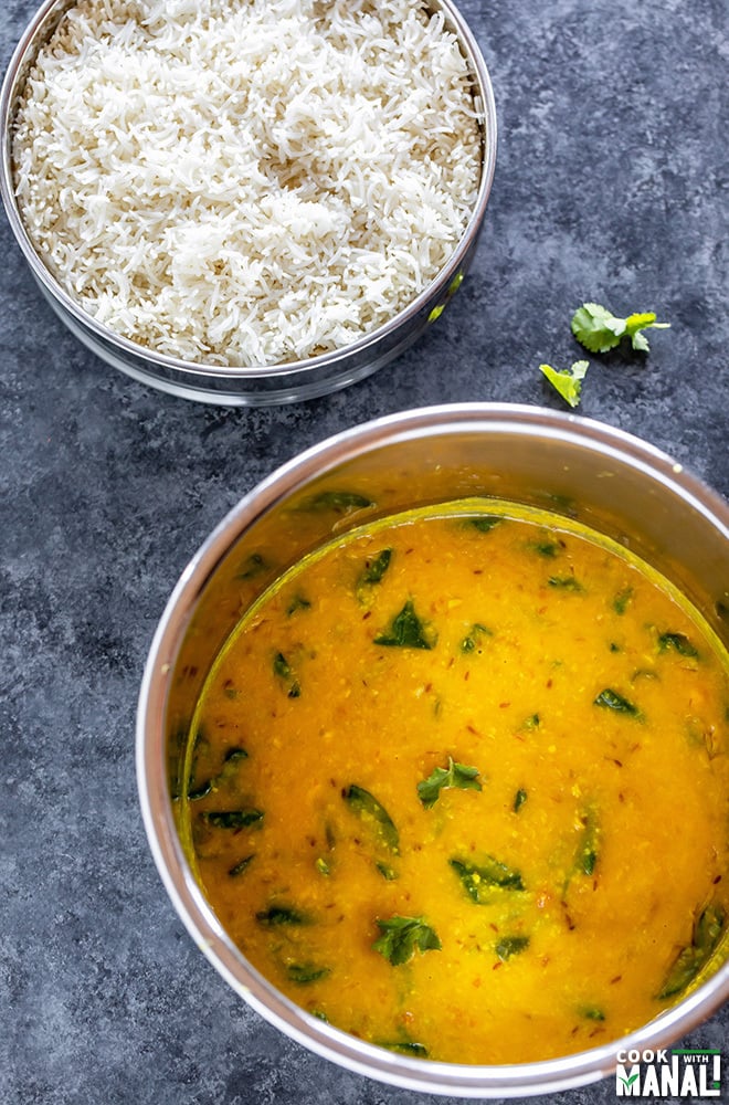 instant pot with cooked dal and a bowl of rice in the back