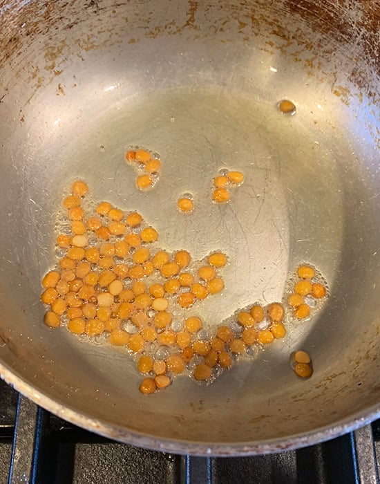raw chana dal being cooked in kadai