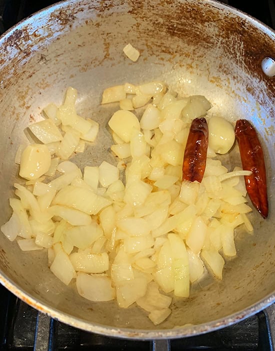 chopped onions with dried red chilies in kadai