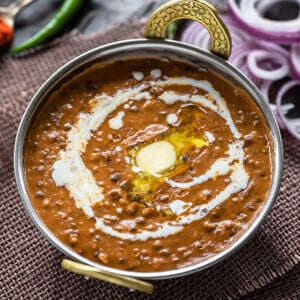 dal makhani served in a copper kadai topped with butter and cream