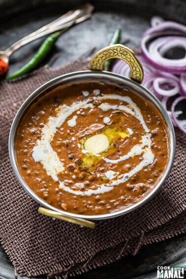 dal makhani served in a copper kadai topped with butter and cream