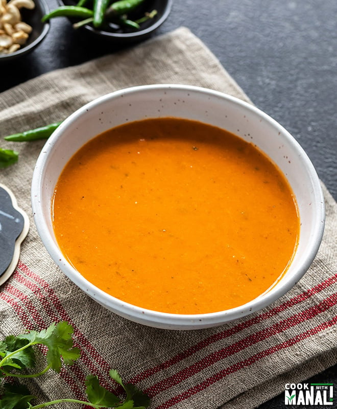 vegan makhani sauce served in a white bowl with some cilantro on the side