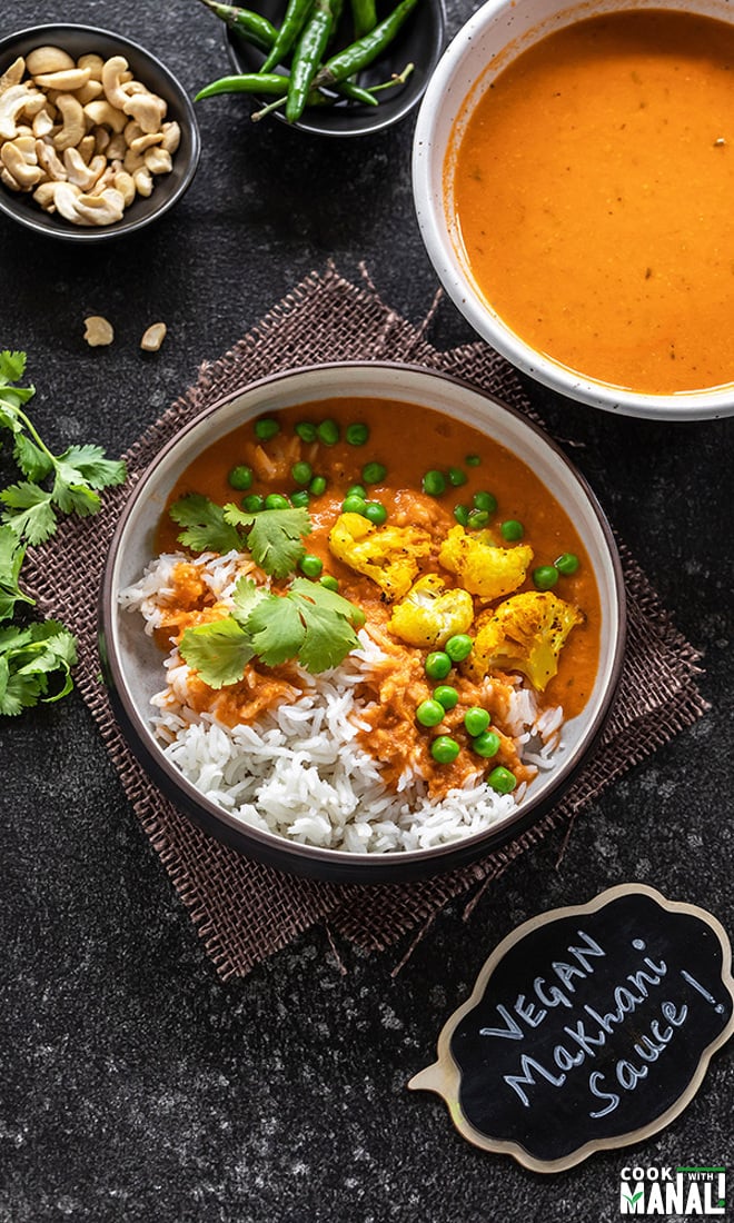 shot of vegan makhani sauce with cauliflower and green peas served over white rice and garnished with cilantro. 