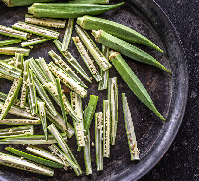 black tray with okra, some whole and some cut into slices