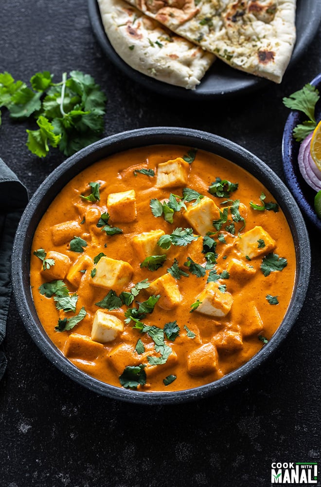 bowl of paneer butter masala garnished with cilantro