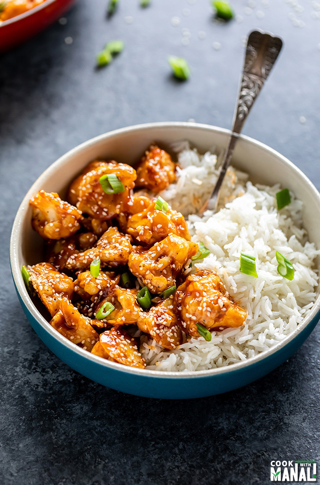 sesame cauliflower served with white rice in a blue bowl