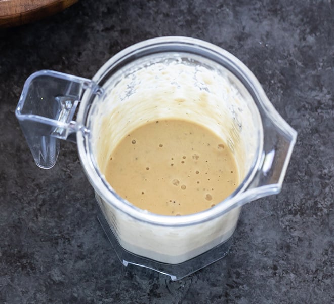 a blender jar with a smooth salad dressing