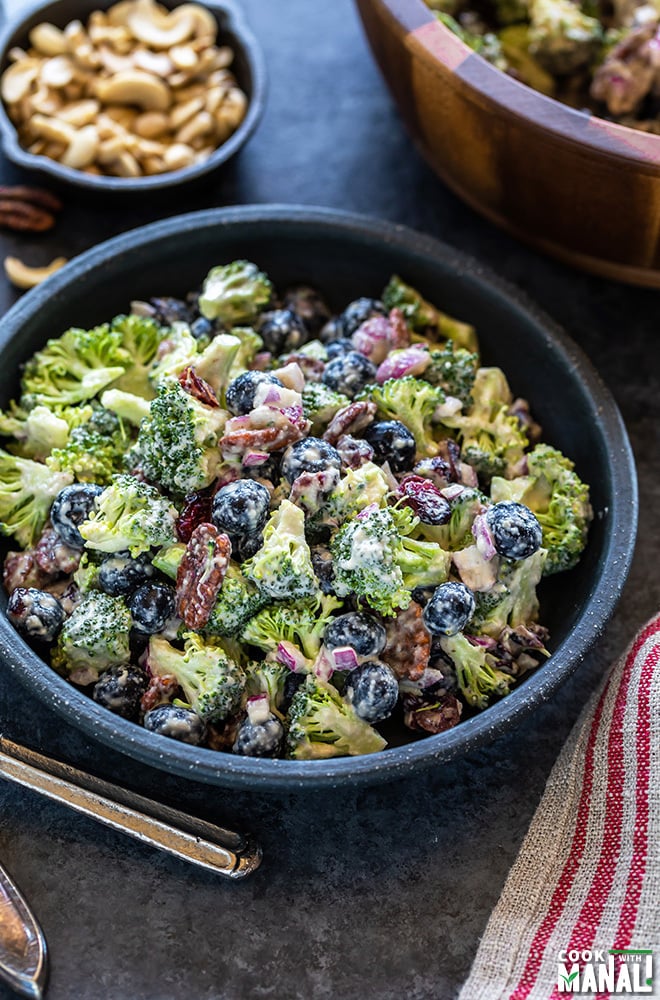 bowl of vegan broccoli salad with blueberries and a fork on the side