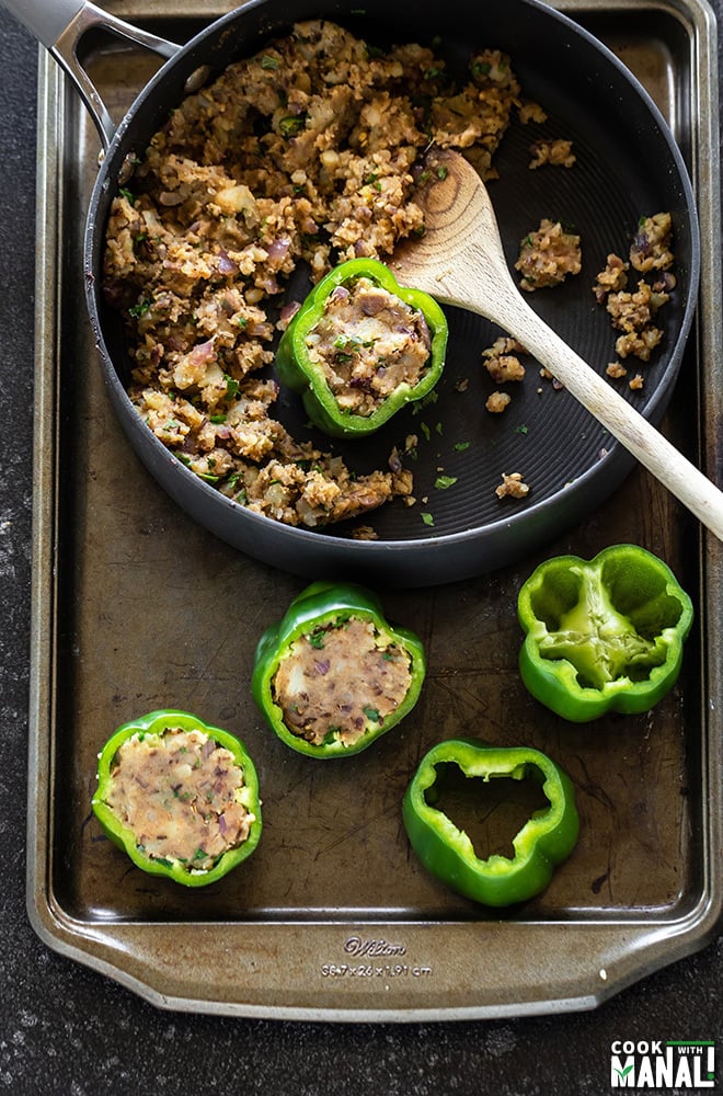 process shot showing green bell peppers being stuffed with potato filling, while some are stuffed, some are hollow