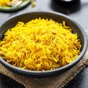 saffron rice in a black bowl with a small bowl of saffron strands in the background