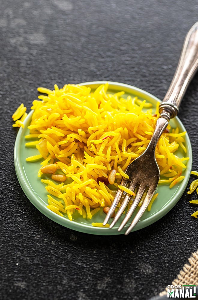saffron rice in a small round blue plate with a fork
